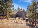 Charming home exterior highlighting the home's lush landscaping and mountain setting at 3817 Ponderosa Dr, Evergreen, CO 80439