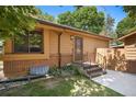 View of a charming front porch with stairs leading to the front door, and beautiful landscaping at 136 S Eagle Cir, Aurora, CO 80012