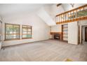 Spacious living room with vaulted ceilings, a fireplace, large windows, and a cozy atmosphere at 136 S Eagle Cir, Aurora, CO 80012