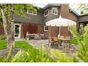Inviting backyard with stone patio, modern furniture, and a charming fire pit for outdoor gatherings at 10000 E Ohio Ave, Denver, CO 80247