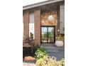 Inviting front entrance with stone accents, modern lighting, and tasteful landscaping at 10000 E Ohio Ave, Denver, CO 80247