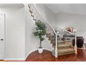 A beautiful foyer with wood floors, a curving staircase, and a decorative plant for an inviting entrance at 9453 Lark Sparrow Dr, Highlands Ranch, CO 80126