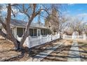 A view of the side of the home with a long screened-in porch with a concrete walkway and mature landscaping at 6025 S Sycamore St, Littleton, CO 80120