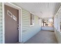 The enclosed front porch with weathered green siding features a secure entrance door, and provides weather protection at 6025 S Sycamore St, Littleton, CO 80120