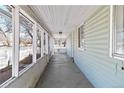 Long enclosed porch with white trim and flooring, offering an inviting space with ample natural light at 6025 S Sycamore St, Littleton, CO 80120