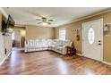 Spacious living room featuring gleaming hardwood floors and a comfortable white leather sofa at 1881 E 95Th Ave, Thornton, CO 80229
