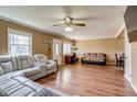 Open-concept living room with a ceiling fan and a neutral color palette and wood floors at 1881 E 95Th Ave, Thornton, CO 80229