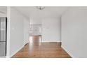 Open-concept living space with gleaming hardwood floors and neutral wall colors at 3212 Uvalda St, Aurora, CO 80011