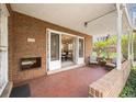 Inviting patio with red brick, stylish outdoor furniture, and a view into a bright dining area through glass doors at 3942 E Evans Ave, Denver, CO 80210