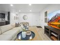 Inviting living room features a cozy sofa, decorative accents, and television at 9340 Pierce St, Westminster, CO 80021