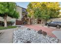 Apartment building exterior with stone landscaping and red brick walkway at 2281 S Vaughn Way # 118A, Aurora, CO 80014