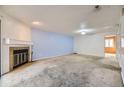 Spacious living room with a fireplace, blue accent wall, and neutral-colored carpet at 3050 W 32Nd Ave # 102C, Denver, CO 80211