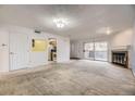 Living room with fireplace, sliding glass doors, and view into the kitchen at 3050 W 32Nd Ave # 102C, Denver, CO 80211