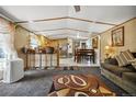 Open-concept living space featuring kitchen, dining area and carpeted living room with contemporary decor at 422 Willow Dr, Lochbuie, CO 80603