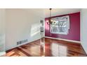Dining room features hardwood floors, purple accent wall, and chandelier above a window at 17045 Hastings Ave, Parker, CO 80134