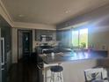 Well lit kitchen with stainless appliances, large island, updated countertops, and dark wood floors at 3811 Lisbon Ct, Denver, CO 80249