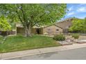 Charming brick home features a landscaped front yard with mature trees, a walkway, and an attached garage at 3444 S Bellaire St, Denver, CO 80222