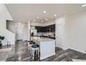 Open kitchen featuring a center island with bar stools, modern appliances, and sleek cabinetry at 3611 S Perth Cir # 103, Aurora, CO 80013