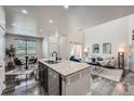 Bright living space featuring a modern kitchen island, dining area, and stylishly decorated living room with neutral tones at 3611 S Perth Cir # 103, Aurora, CO 80013