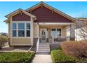 Charming two-story home with red and tan accents and a welcoming front porch entrance under a blue sky at 19795 W 57Th Ave, Golden, CO 80403