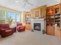Cozy living room with a fireplace, built-in shelving, large windows, and comfortable seating at 19795 W 57Th Ave, Golden, CO 80403