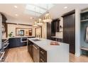 Stylish kitchen boasting a large island, dark cabinetry, and stainless steel appliances at 853 Saint Paul St, Denver, CO 80206