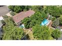 Aerial view of a home nestled among mature trees, featuring a backyard pool and patio area at 8130 E Bethany Pl, Denver, CO 80231
