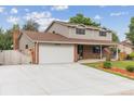 Inviting two-story home with brick and siding, large garage and driveway, and well-kept lawn with garden at 13225 Peacock Dr, Lone Tree, CO 80124