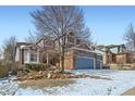 Charming two-story home with a three-car garage and beautiful rock landscaping with snow at 2105 Keota Ln, Superior, CO 80027