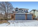 Charming two-story home with a three-car garage and a beautiful blue exterior on a sunny day at 2105 Keota Ln, Superior, CO 80027