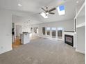 Bright living room showcasing vaulted ceilings, skylights, and fireplace at 7292 Firethorn, Littleton, CO 80125