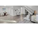 Open living area showcasing wood floors, modern decor, dining area and staircase at 10001 E Evans Ave # 58B, Aurora, CO 80247