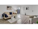 Bright living room with wood flooring, modern furnishings, and a sliding glass door at 10001 E Evans Ave # 58B, Aurora, CO 80247