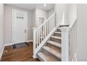 Bright entryway with wood floors and a carpeted staircase at 1632 Saddlesmith Pl, Castle Pines, CO 80108