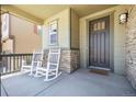 Inviting front porch with two rocking chairs offers a relaxing outdoor space at 1632 Saddlesmith Pl, Castle Pines, CO 80108