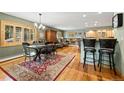 Open-concept dining area featuring a rustic table, ornate rug, and bar seating adjacent to the living area at 100 River Park Dr # A, Breckenridge, CO 80424
