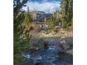Beautiful mountain home with creek in foreground, trees, and blue sky at 100 River Park Dr # A, Breckenridge, CO 80424
