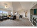 Bright living room featuring vaulted ceilings, neutral paint, ceiling fan, and open access to the dining area at 12931 Ironstone Way # 303, Parker, CO 80134