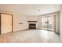 Inviting living room featuring a fireplace, sliding glass doors, and light, wood-look floors at 1074 S Dearborn St # 108, Aurora, CO 80012