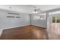 Spacious living room features hardwood floors, a ceiling fan, and a seamless view into the kitchen at 11050 Gaylord St, Northglenn, CO 80233