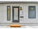 Close-up of a modern front door with sidelight, stylish sconce, and visible house number at 2162 S Ash St, Denver, CO 80222