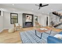 Contemporary living room featuring a sleek fireplace, hardwood floors, and open staircase at 2162 S Ash St, Denver, CO 80222