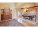 Elegant dining room showcasing a wooden arched entry door, chandelier and a large table for gatherings at 18720 Lake Dr, Monument, CO 80132