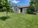 Well maintained home exterior with expansive lawn and established landscaping at 1140 S Xavier St, Denver, CO 80219