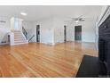 Spacious living room boasts gleaming hardwood floors, a modern ceiling fan, and a cozy fireplace at 3530 Dahlia St, Denver, CO 80207
