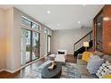 Bright living room featuring large windows, a modern staircase, and contemporary furnishings at 3195 Blake St # 106, Denver, CO 80205