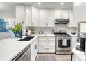 Bright kitchen featuring modern appliances, quartz countertops, and white shaker cabinets at 1811 S Quebec Way # 103, Denver, CO 80231