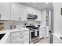 Kitchen with stainless steel appliances, white cabinets, and a white subway tile backsplash at 1811 S Quebec Way # 103, Denver, CO 80231