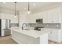 Modern kitchen featuring white cabinetry, quartz countertops, stainless steel appliances, and a stylish backsplash at 5960 S Platte Canyon Dr, Littleton, CO 80123