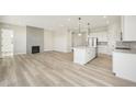 Spacious open-concept living room and kitchen with wood floors, fireplace, and large center island at 5960 S Platte Canyon Dr, Littleton, CO 80123